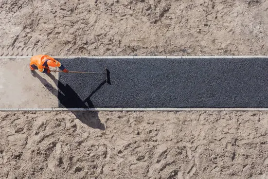 Fresh asphalt being finished on a road surface